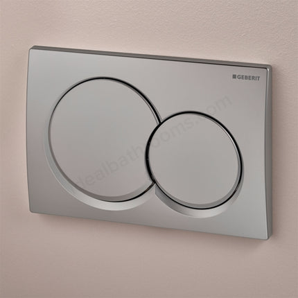 Metallic toilet flush plate with Geberit branding on a beige background