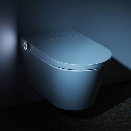 Smart toilet bowl with cover in a dark setting, illuminated by a light source.