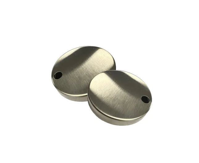Two metallic disc-shaped objects with holes on a white background