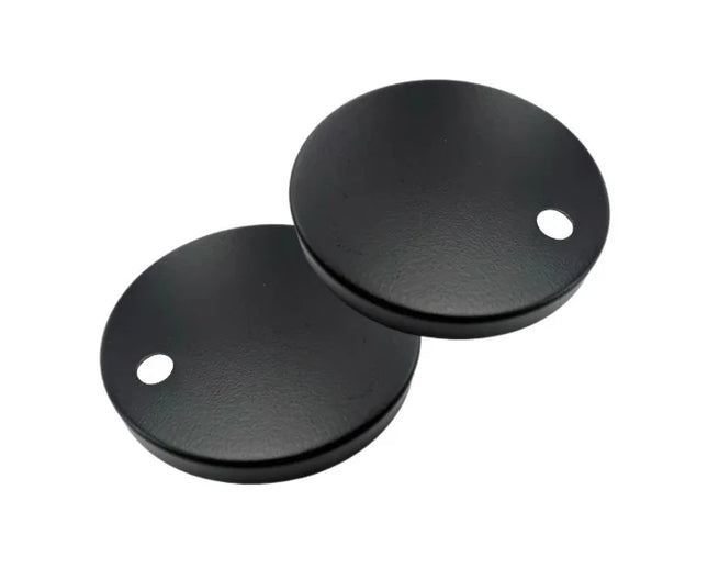 Two black round metal objects with holes on a white background
