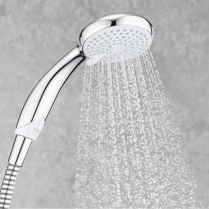 Chrome shower head with water spraying against a gray background