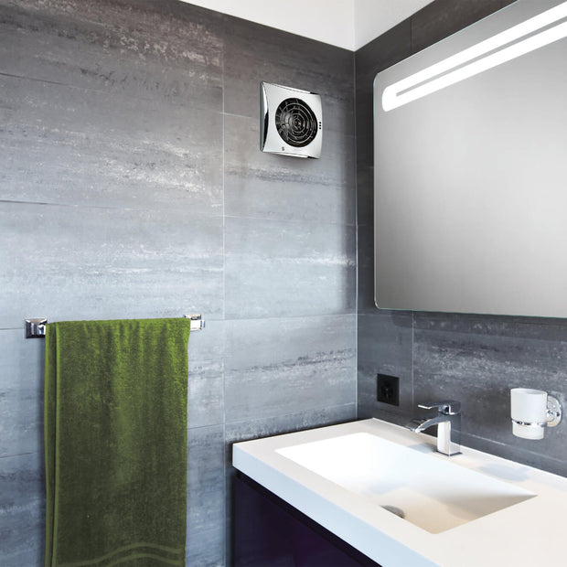 Bathroom interior with a green towel on a rack, sink, and exhaust fan.