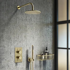 Gold shower head and control panel mounted on a gray wall with a glass door.